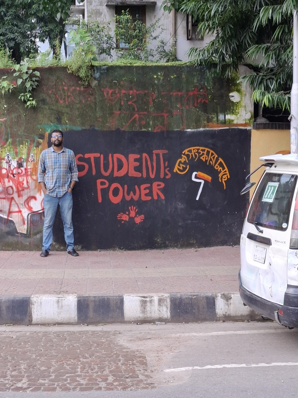 The author in front of another mural referencing the power of student movement, in Dhaka. Photo: Rifat Bin Latif