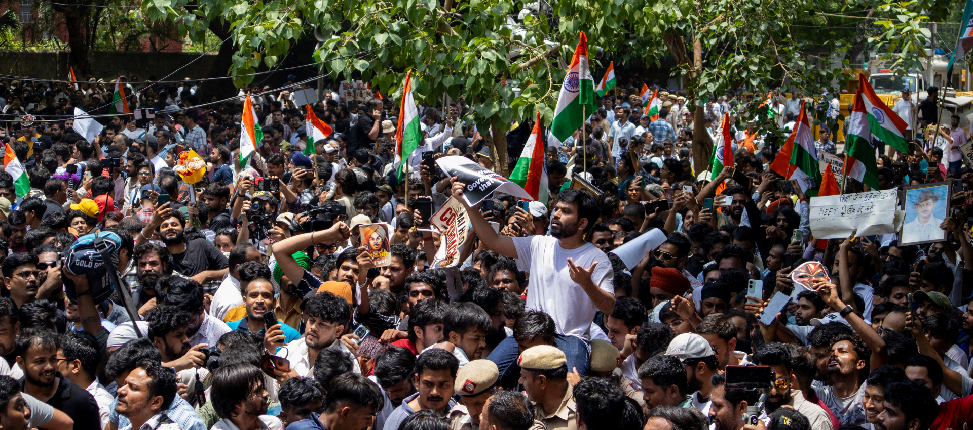 The image shows a huge crowd at Delhi's Jantar Mantar.