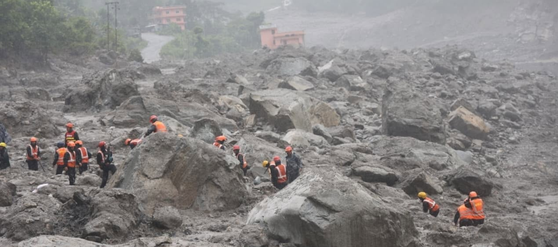 The image shows rescue workers conducting search operations in Nepal.