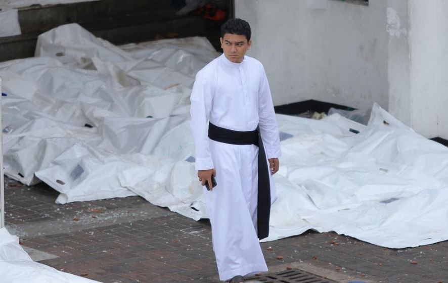A man is seen standing near covered bodies at the site of the Easter Sunday attacks in 2019 in Sri Lanka.