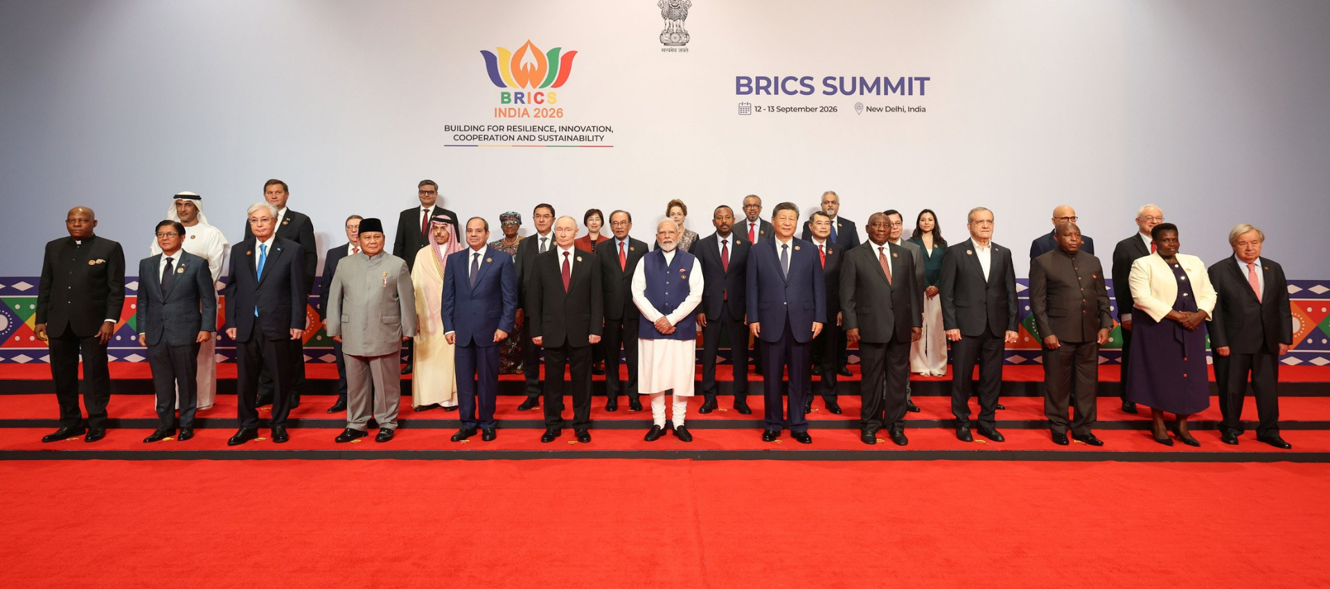 Group photo of BRICS leaders standing on a red-carpeted steps at the BRICS summit in New Delhi in 2026.