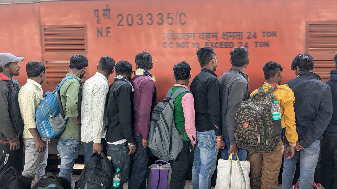 Young migrants in search of work wait to board a train to Andhra Pradesh at the Howrah rail terminus. Photo: Anirban Dey/PARI