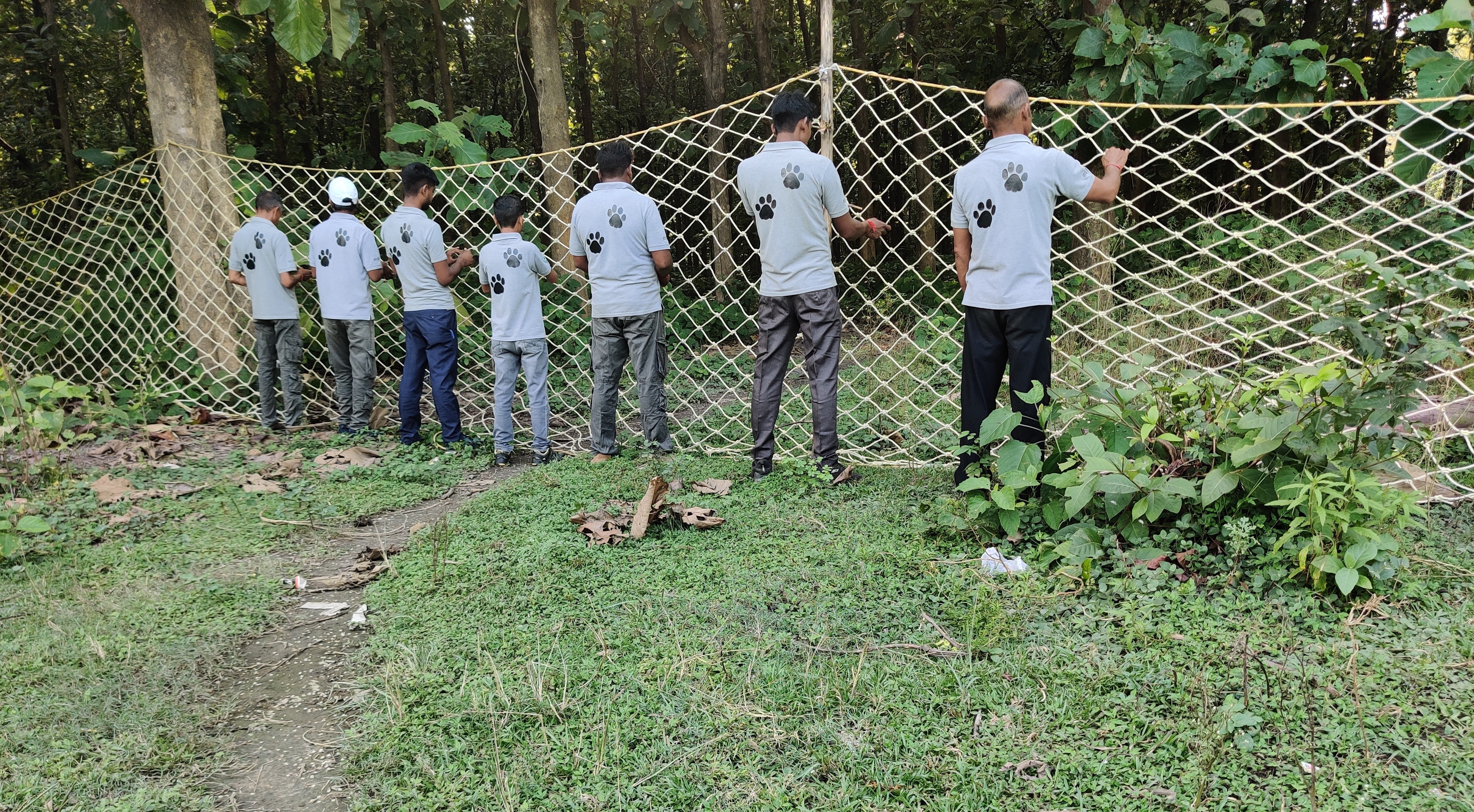 The image shows Bagh Mitras in Puranpur being trained by forest staff.  