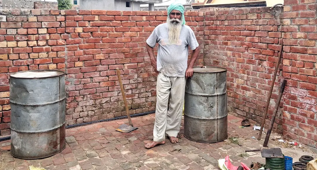 The image shows Dalbara Singh, a landless Dalit farmer, who has had to borrow money to stock up diesel. 